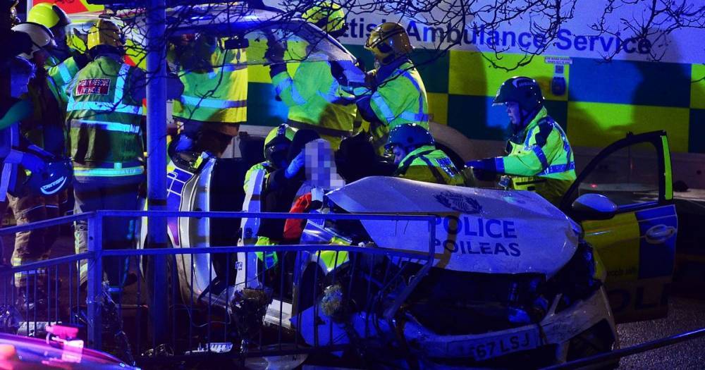 Police car roof chopped off after horror smash in Glasgow as firefighters free injured 'officer' - www.dailyrecord.co.uk