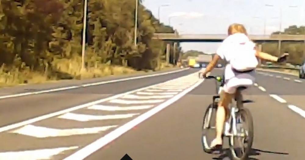 Moment cyclist 'with a death wish' rides across entire M60 carriageway...before raising her hand to say thanks to drivers - www.manchestereveningnews.co.uk - Manchester
