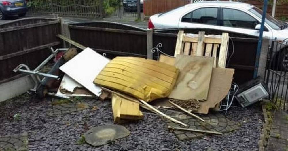 Fly-tippers have dumped a huge pile of rubbish in someone's front garden - including a weight bench, a mattress and even an old microwave - www.manchestereveningnews.co.uk