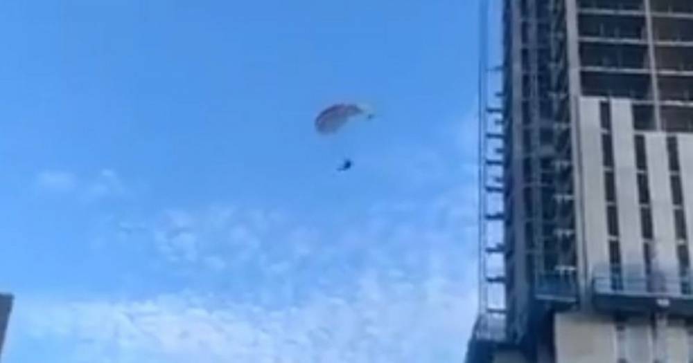 WATCH: Moment daredevil parachutes from top of high-rise building in Ancoats - www.manchestereveningnews.co.uk
