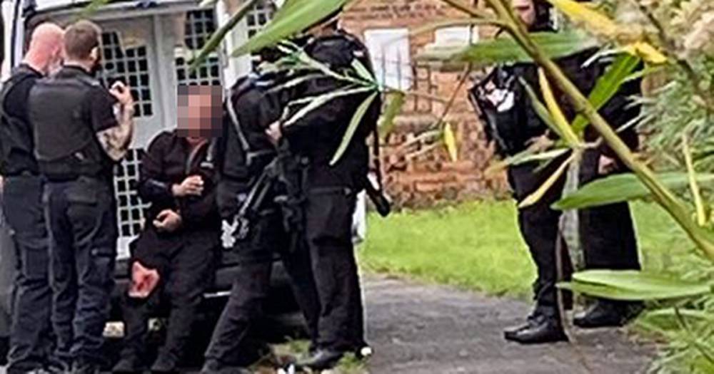 'Armed cops' rush to street before man arrested following reports of people being 'threatened with an axe' - www.manchestereveningnews.co.uk