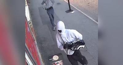 CCTV image of two hooded men released by police investigating machete and knife robbery in Oldham - www.manchestereveningnews.co.uk - Manchester - county Oldham - county Lane