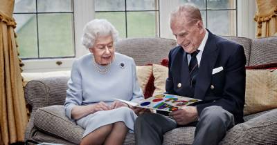 The Queen and Prince Philip beam as they read homemade anniversary card by George, Charlotte and Louis - www.ok.co.uk