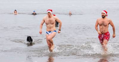 Dozens of swimmers brave freezing water for Christmas Day swim at Edinburgh beach - www.dailyrecord.co.uk - Scotland - Santa
