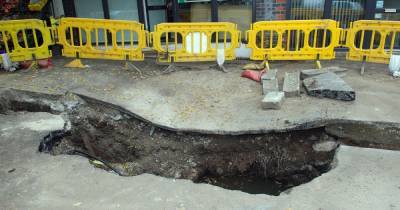 The MASSIVE hole that has appeared outside a row of shops...it's 'getting bigger and bigger' - www.manchestereveningnews.co.uk
