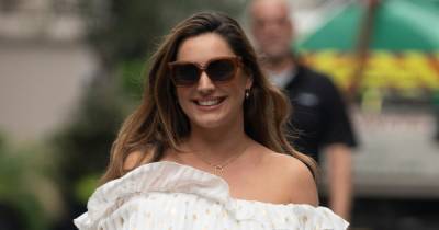 Kelly Brook shows off her incredible curves in an off-the-shoulder white dress as she leaves work - www.ok.co.uk