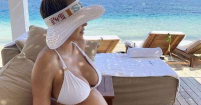 Kate Ferdinand shows off blossoming baby bump in white bikini as she enjoys another family holiday - www.msn.com