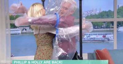 Holly Willoughby and Phillip Schofield use 'cuddle curtain' to hug for first time in 6 months - www.msn.com