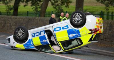 Boy, 15, arrested after police car ends on roof in chase after knife-point car-jacking - www.manchestereveningnews.co.uk - county Oldham