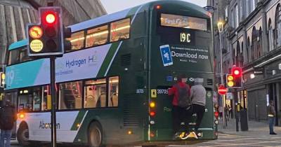 'Numpty' youths pictured hitching lift on back of moving bus in busy Scots city centre - www.dailyrecord.co.uk - Scotland - city Aberdeen
