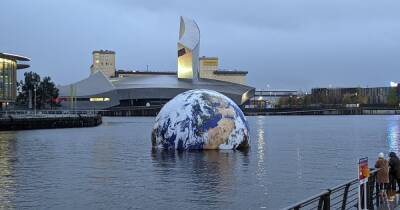 Floating Earth sculpture SINKS as extreme weather hits Salford Quays - www.manchestereveningnews.co.uk - Manchester - Santa