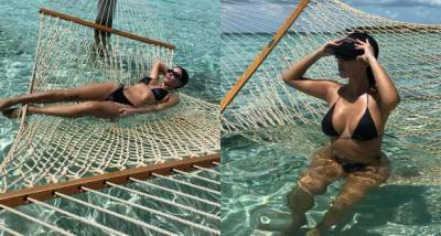 Kim Kardashian cools off in a black bikini as she lounges in crystal blue water amid Kanye West divorce - www.pinkvilla.com