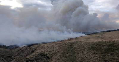 The scene on Marsden Moor this morning as fire crews and a helicopter continue to tackle blaze - www.manchestereveningnews.co.uk