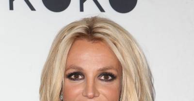 Britney Spears shows off secret tattoo in hot pink swimsuit - www.wonderwall.com