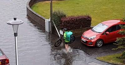 Determined UberEats courier filmed taking socks and shoes off as he battles through floods to deliver takeaway - www.dailyrecord.co.uk