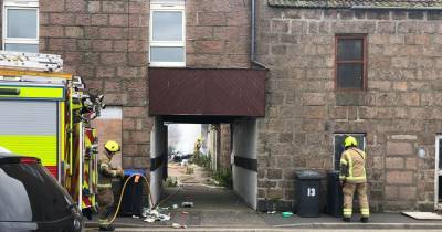 Dramatic images show firefighter smashing down door of building after blaze in back garden of Scots flats - www.dailyrecord.co.uk - Scotland