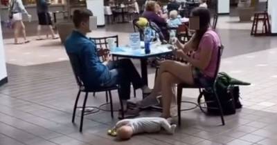 Shoppers outraged as parents leave baby lying on floor while they ate dinner - www.dailyrecord.co.uk