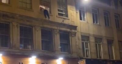 Shocking footage captures moment reckless man dangles from third-floor window in Scots street - www.dailyrecord.co.uk - Scotland