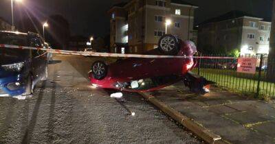 Road taped off by police after car flips onto roof in crash - www.manchestereveningnews.co.uk - Manchester