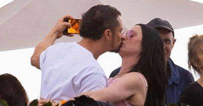 Katy Perry and Orlando Bloom pack on the PDA as they kiss at Bruce Springsteen concert - www.ok.co.uk - California