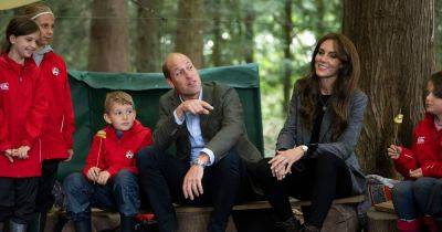Kate and William are happy campers as they help kids prepare food around campfire - www.ok.co.uk