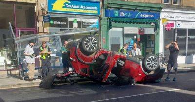 Car destroys bus stop after flipping on its roof in busy city street - www.dailyrecord.co.uk - Scotland - Beyond