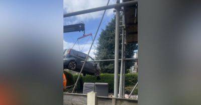 Car lifted away from crash scene as house is 'propped up' after devastating smash - www.manchestereveningnews.co.uk - Manchester